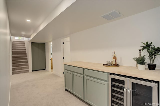 bar featuring elevator, beverage cooler, and light carpet