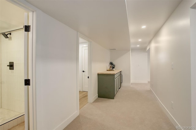 hallway featuring light colored carpet