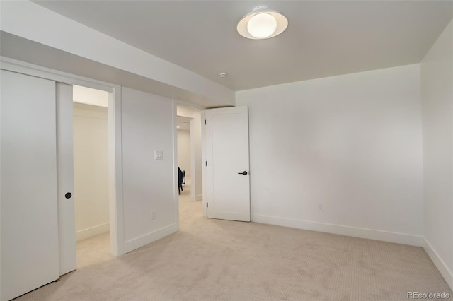 unfurnished bedroom featuring light carpet and a closet