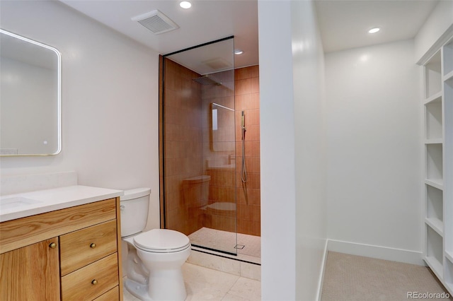 bathroom featuring tile patterned flooring, vanity, tiled shower, and toilet