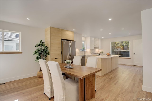 dining area with sink and light hardwood / wood-style flooring