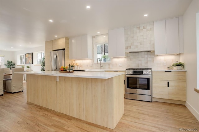 kitchen with white cabinetry, appliances with stainless steel finishes, and a kitchen island