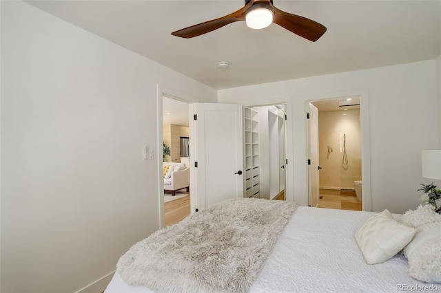 bedroom featuring a walk in closet, connected bathroom, ceiling fan, and a closet