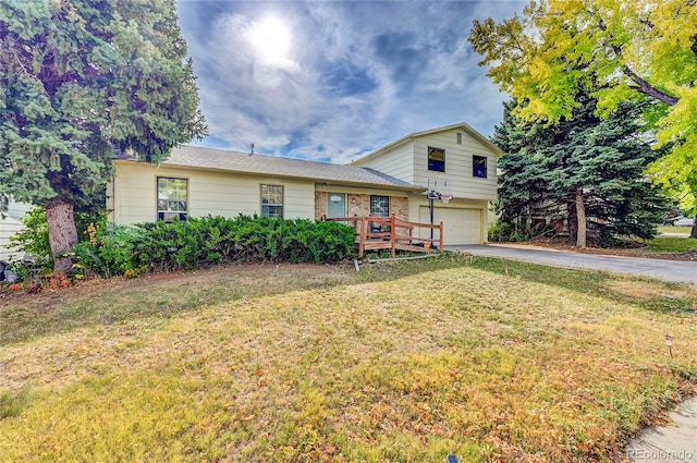 split level home with a front yard, a deck, and a garage