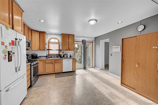 1550 S Telluride St, Aurora, CO 80017 - kitchen with stainless steel appliances, brown cabinets, a sink, light countertops, and baseboards
