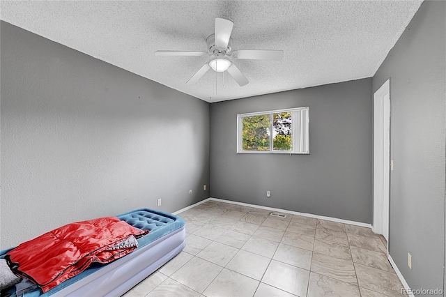 unfurnished bedroom with a textured ceiling and ceiling fan