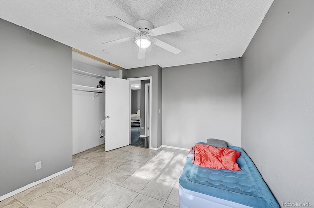 bedroom featuring a closet, a textured ceiling, and ceiling fan