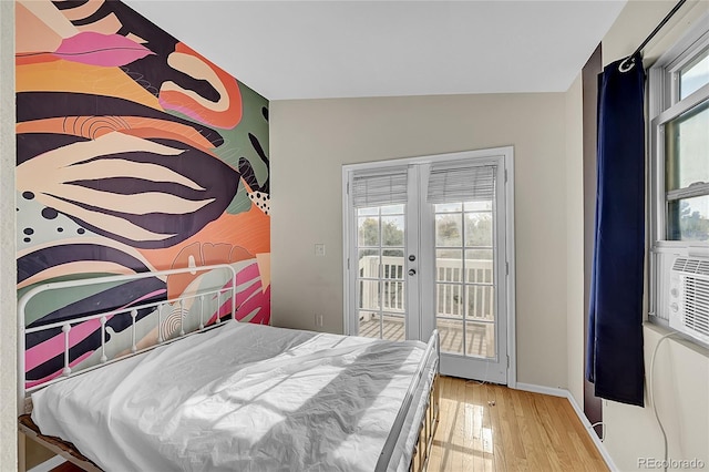 bedroom with french doors, multiple windows, access to exterior, and wood-type flooring