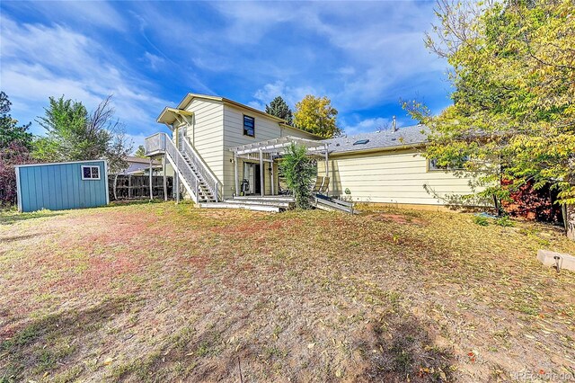 1550 S Telluride St, Aurora, CO 80017 - back of house featuring an outdoor structure, a pergola, a shed, stairway, and fence