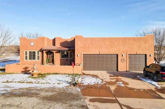 pueblo-style house with a garage