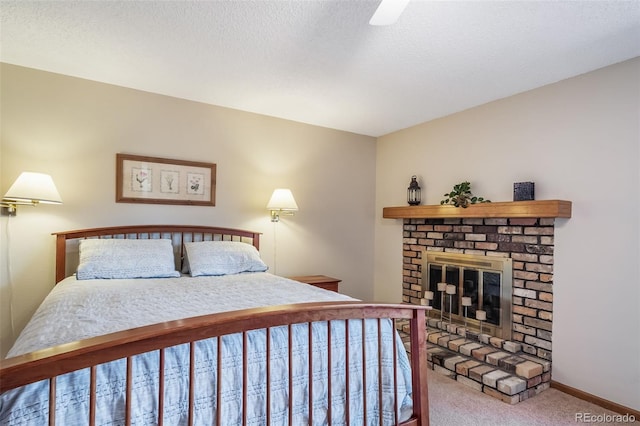 carpeted bedroom featuring a brick fireplace, baseboards, and ceiling fan