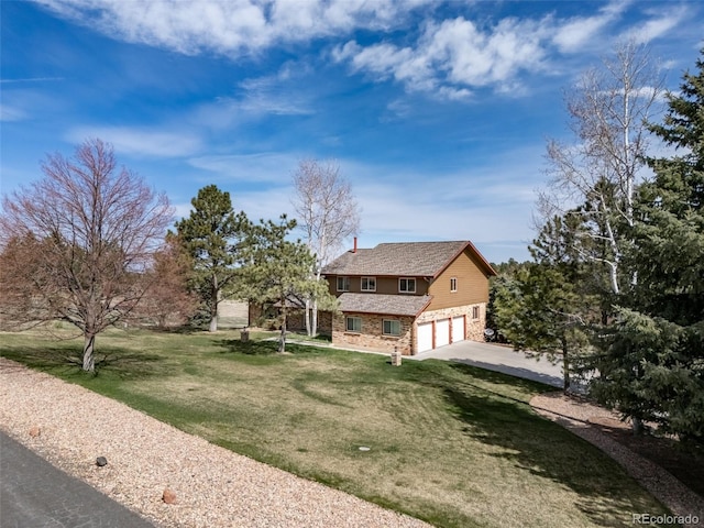 view of front of house featuring an attached garage, driveway, a front lawn, and stone siding