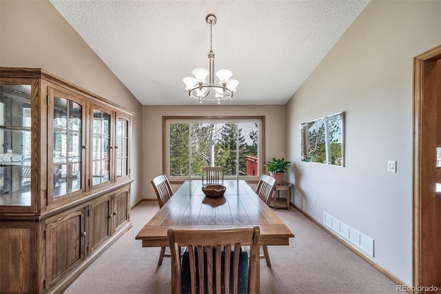 dining area with a textured ceiling, visible vents, vaulted ceiling, a notable chandelier, and light carpet
