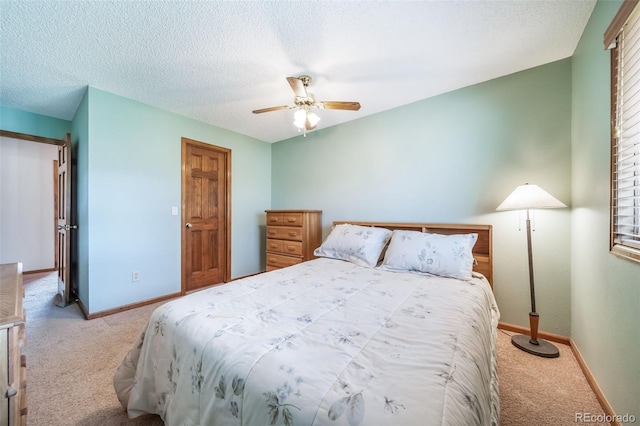 carpeted bedroom featuring baseboards, ceiling fan, and a textured ceiling