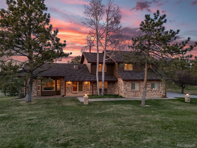 view of front of home with a yard and brick siding