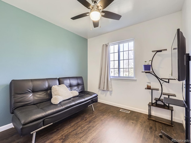 living area featuring dark wood-type flooring and ceiling fan