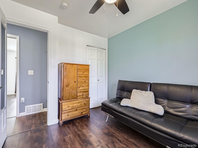 living area with dark wood-type flooring and ceiling fan