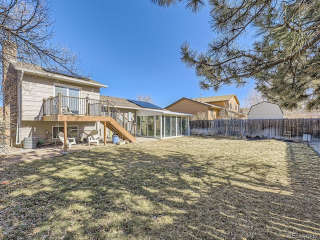 back of property featuring central AC, a deck, a sunroom, and a lawn