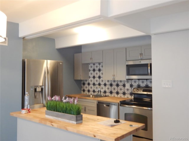 kitchen with wooden counters, appliances with stainless steel finishes, and sink