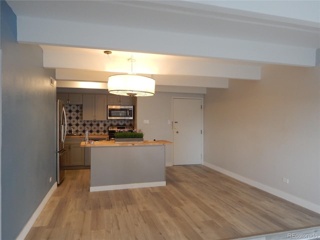 kitchen featuring tasteful backsplash, gray cabinetry, stainless steel appliances, light hardwood / wood-style floors, and hanging light fixtures