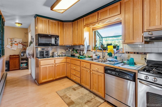 kitchen featuring appliances with stainless steel finishes, light hardwood / wood-style floors, backsplash, sink, and extractor fan