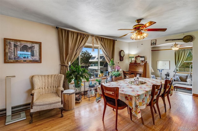 dining space featuring light wood-type flooring and ceiling fan