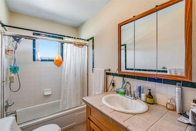 full bathroom with tile walls, decorative backsplash, shower / tub combo, vanity, and toilet