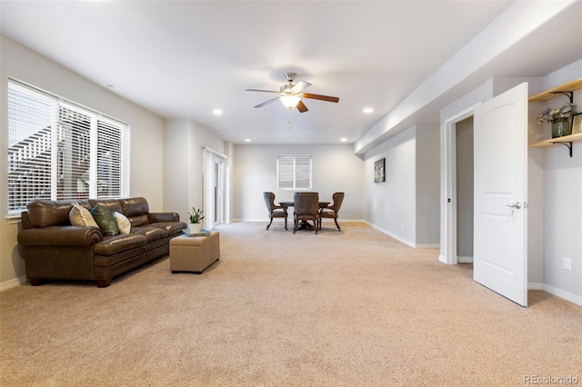 carpeted living room with ceiling fan