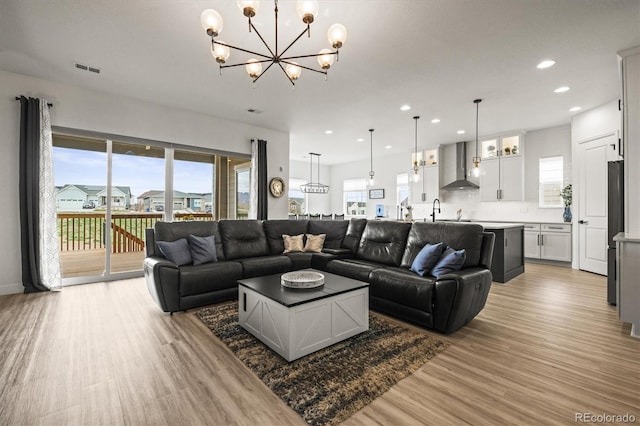8985 Chalk Creek Pl, Littleton, CO 80125 - living area featuring light wood-style floors, a chandelier, and recessed lighting