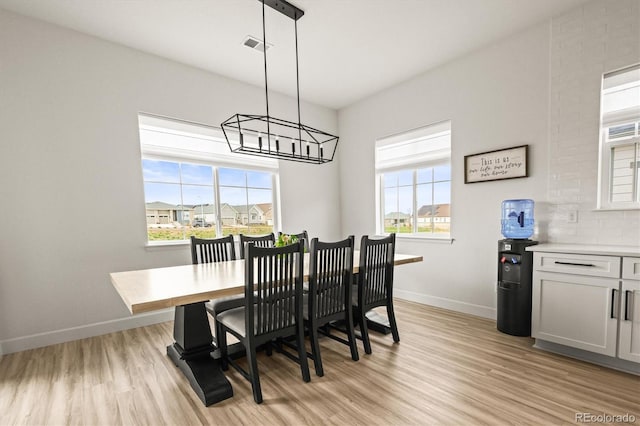 8985 Chalk Creek Pl, Littleton, CO 80125 - dining space with a chandelier, baseboards, light wood finished floors, and healthy amount of natural light