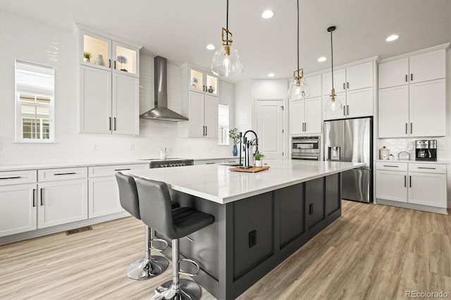 8985 Chalk Creek Pl, Littleton, CO 80125 - kitchen featuring wall chimney range hood, stainless steel fridge, recessed lighting, decorative backsplash, and white cabinetry