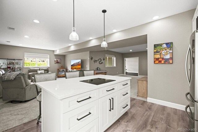 8985 Chalk Creek Pl, Littleton, CO 80125 - kitchen featuring open floor plan, freestanding refrigerator, black electric cooktop, wood finished floors, and a center island
