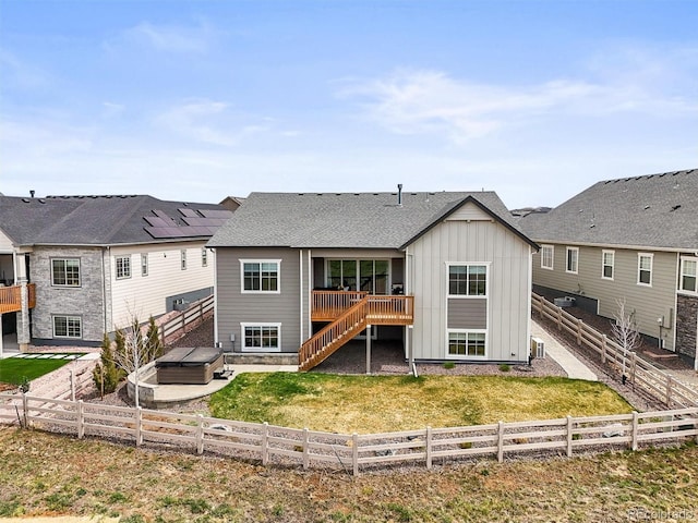 8985 Chalk Creek Pl, Littleton, CO 80125 - back of house featuring board and batten siding, a hot tub, a fenced backyard, and stairs