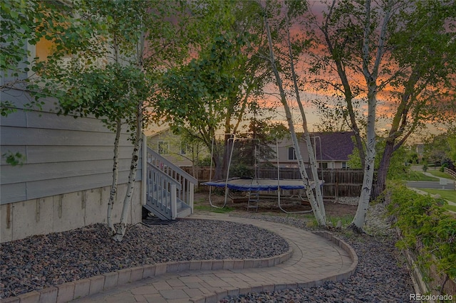 5457 S Valdai St, Aurora, CO 80015 - yard at dusk with a trampoline and stairs