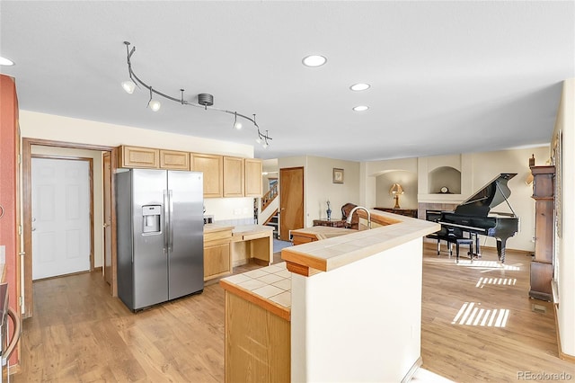 5457 S Valdai St, Aurora, CO 80015 - kitchen with stainless steel refrigerator with ice dispenser, tile countertops, light brown cabinets, light wood-style floors, and recessed lighting
