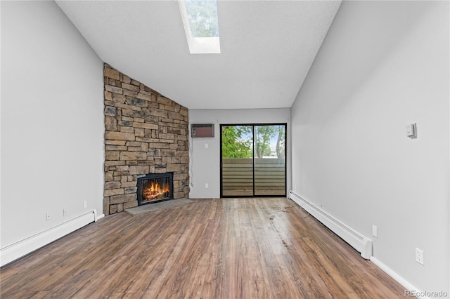 unfurnished living room featuring hardwood / wood-style floors, lofted ceiling with skylight, and a baseboard heating unit