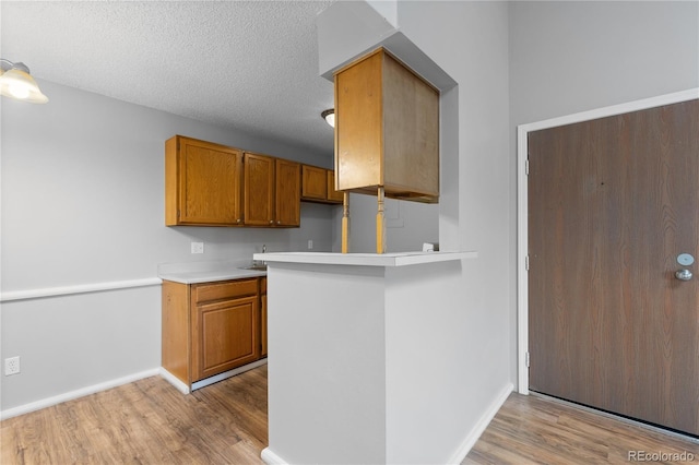 kitchen featuring a textured ceiling and light hardwood / wood-style floors