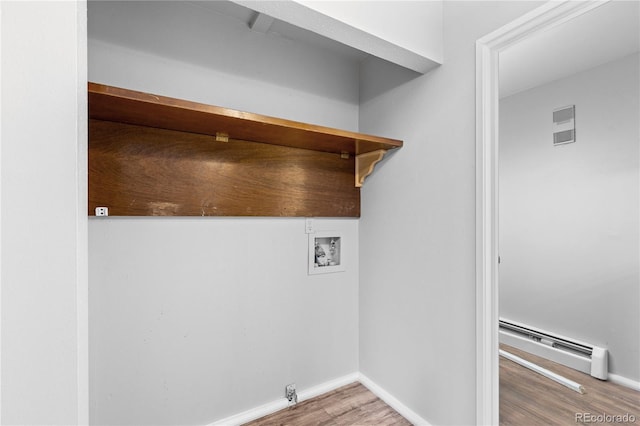 washroom with washer hookup, a baseboard heating unit, and wood-type flooring