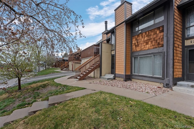 view of property exterior featuring a chimney and stairs