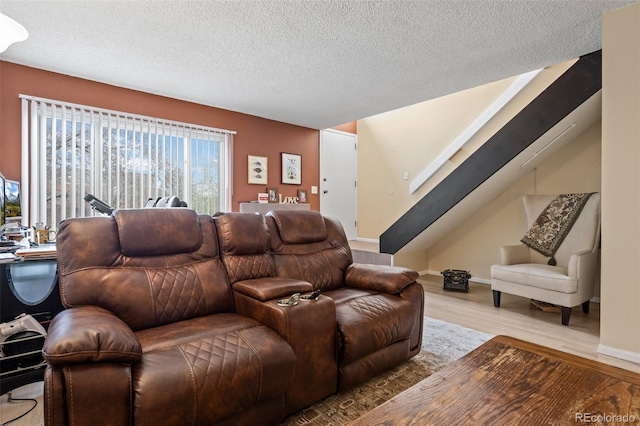 living area featuring stairway, a textured ceiling, and wood finished floors