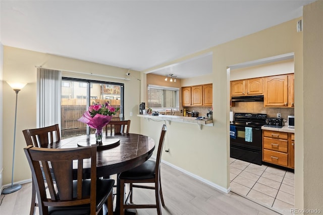 dining area with light wood-type flooring and baseboards