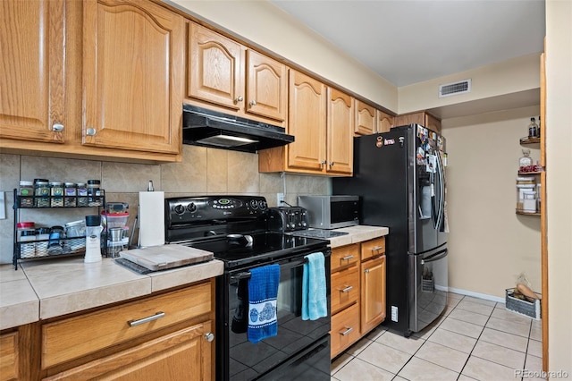 kitchen with visible vents, backsplash, black appliances, under cabinet range hood, and light tile patterned floors