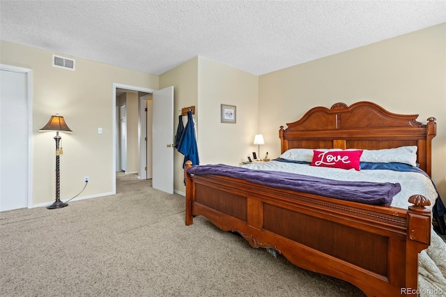 carpeted bedroom featuring a textured ceiling, visible vents, and baseboards