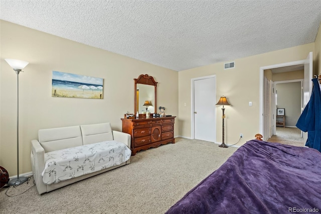 bedroom featuring visible vents, a textured ceiling, and carpet flooring