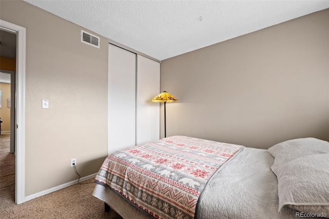 carpeted bedroom with a closet, visible vents, and baseboards