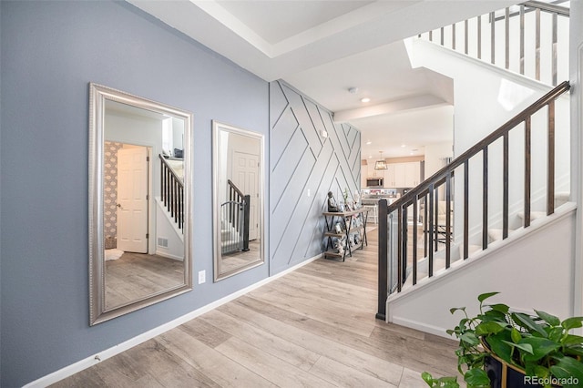 entryway with stairs, wood finished floors, and baseboards