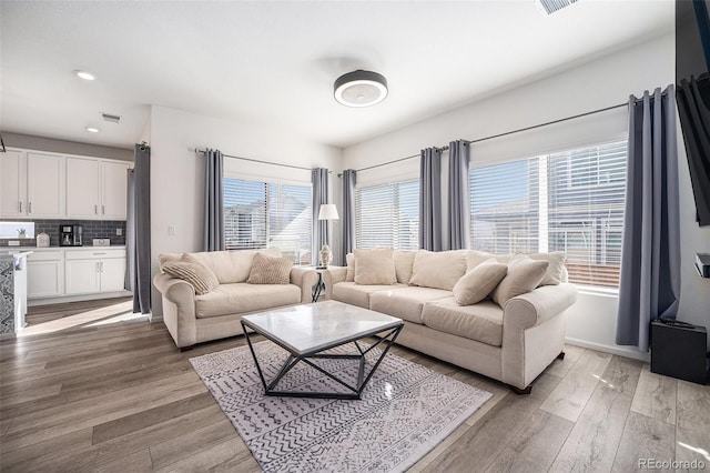 living room featuring recessed lighting, visible vents, light wood finished floors, and baseboards