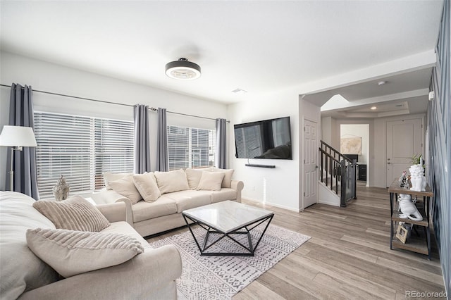 living room featuring recessed lighting, stairway, baseboards, and light wood-style floors