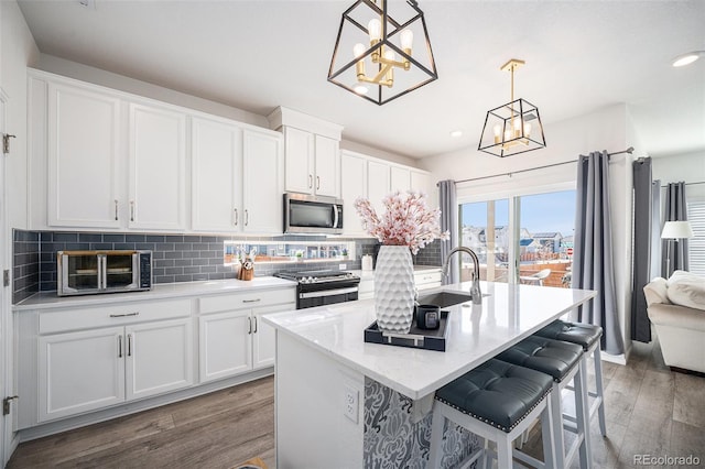 kitchen featuring tasteful backsplash, wood finished floors, stainless steel appliances, and a sink