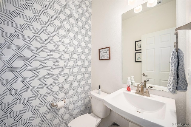 bathroom featuring a sink, a shower with curtain, and toilet